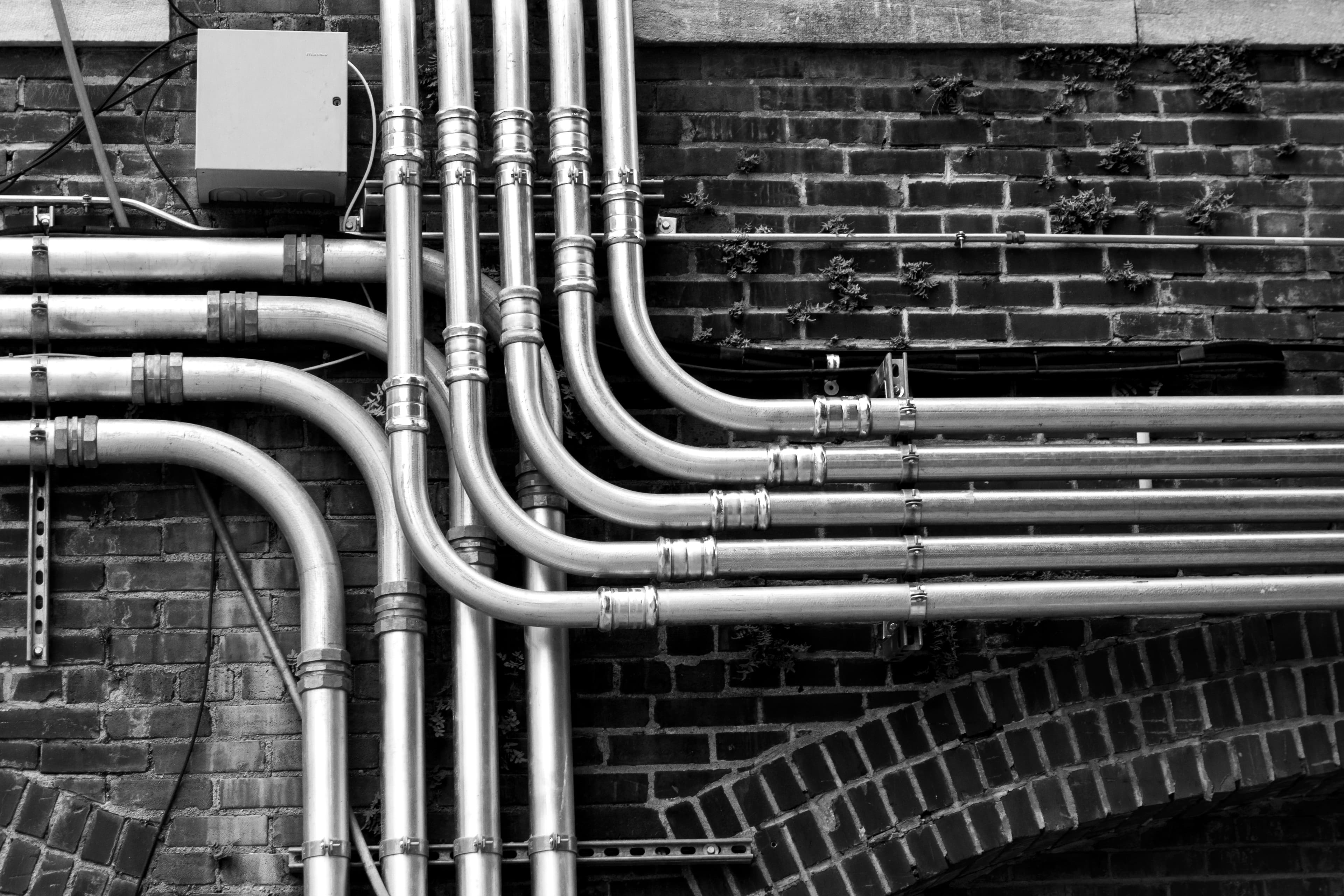 Runs of metallic conduit feeding a junction box on a brick wall